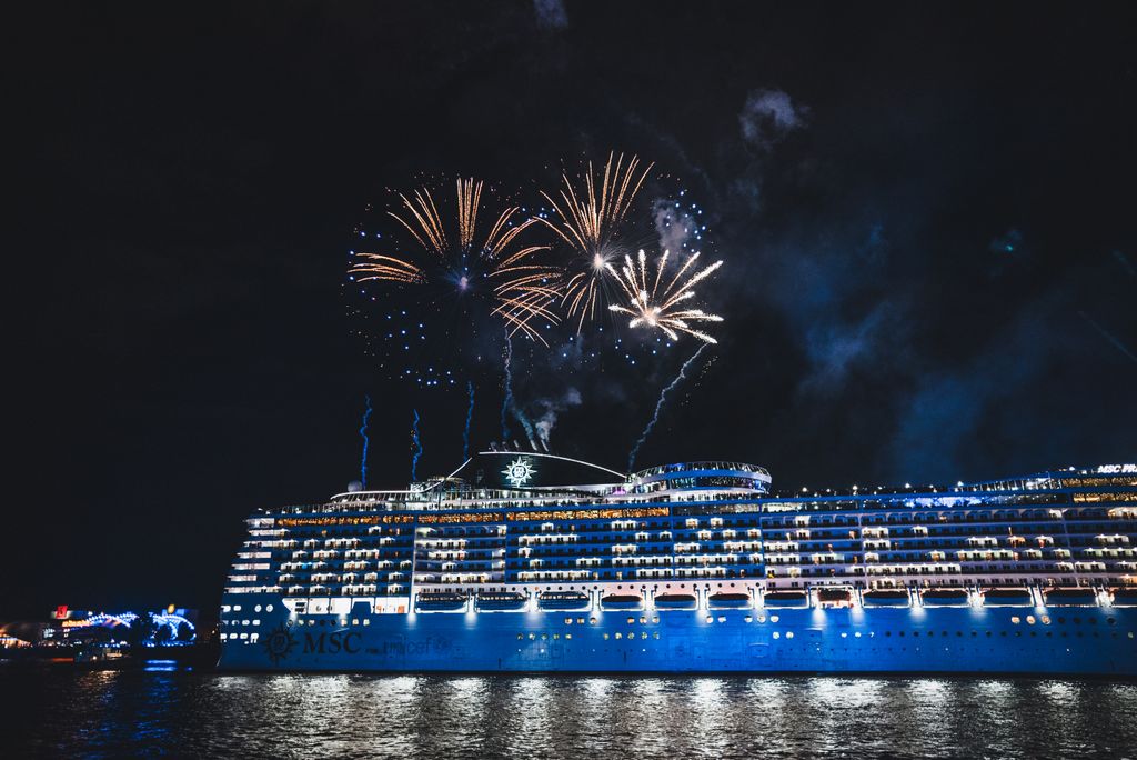 Spectacular fireworks light up the night sky over a cruise ship, offering a stunning sea spectacle.